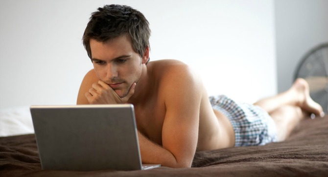 young man with a laptop laying on a bed Četiri načina da vaš penis bude zdrav